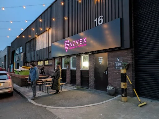 Exterior of Azvex Brewery and Taproom on Gibraltar Row with glowing pink neon sign, festoon lighting and outdoor benches