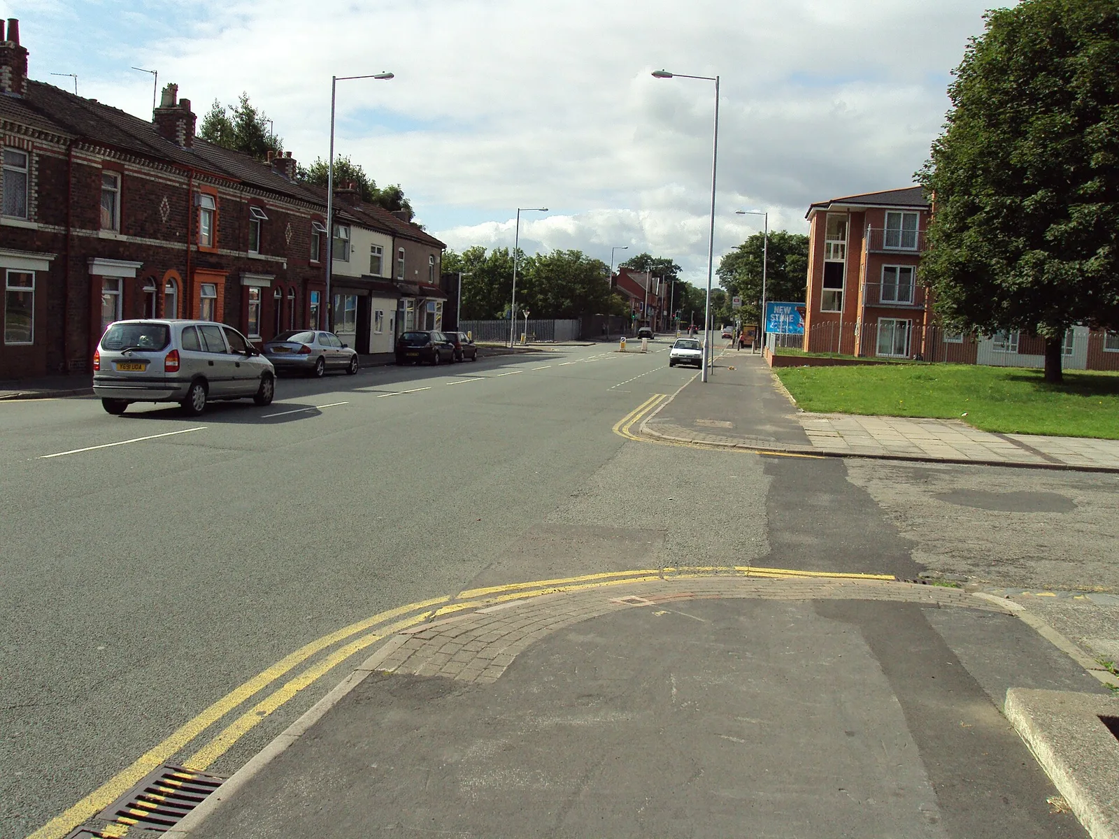 Duke Street in Birkenhead with terraced houses on one side, parked cars and a wide pavement with double yellow lines