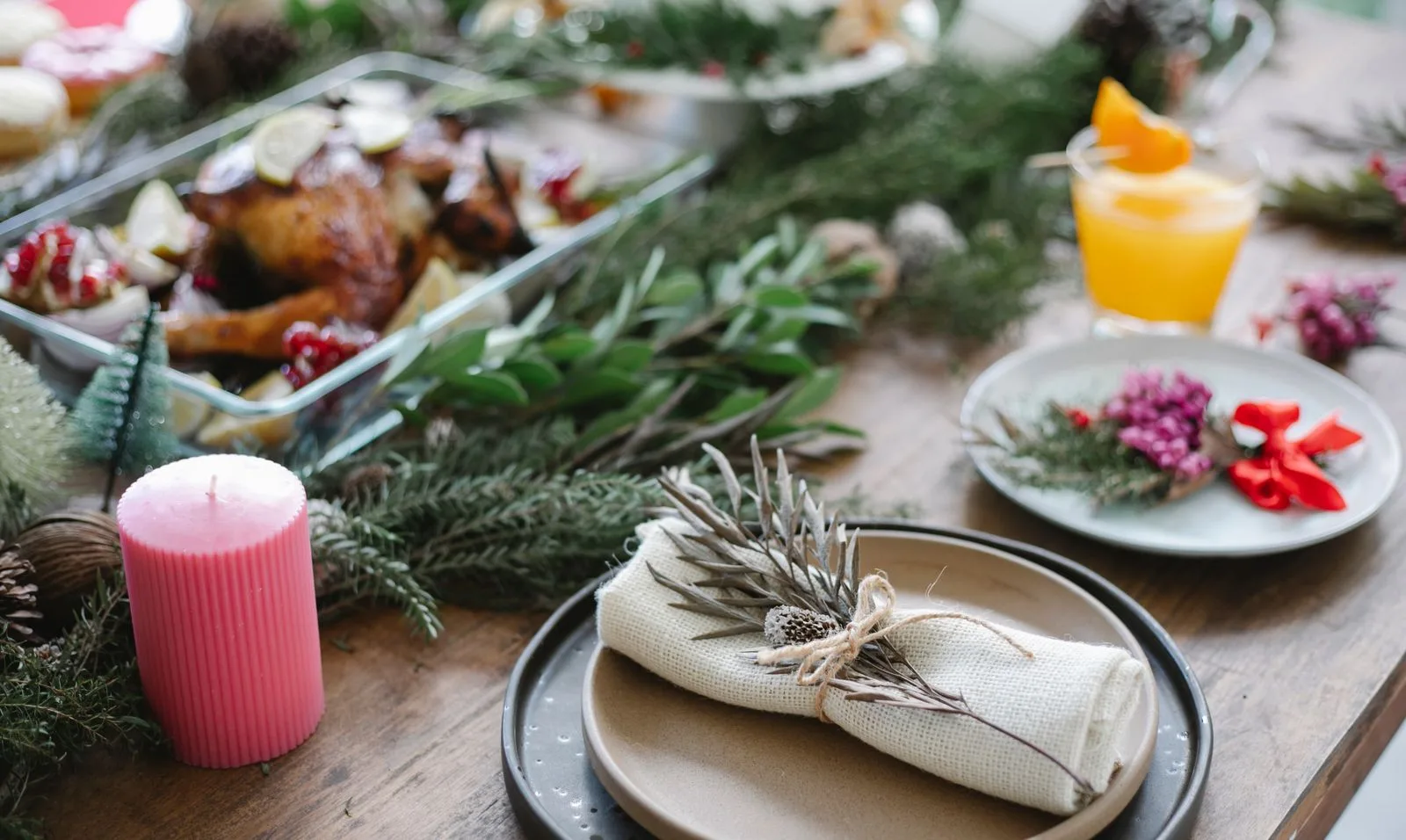 A Christmas dinner table laid with roast turkey, plates and candles