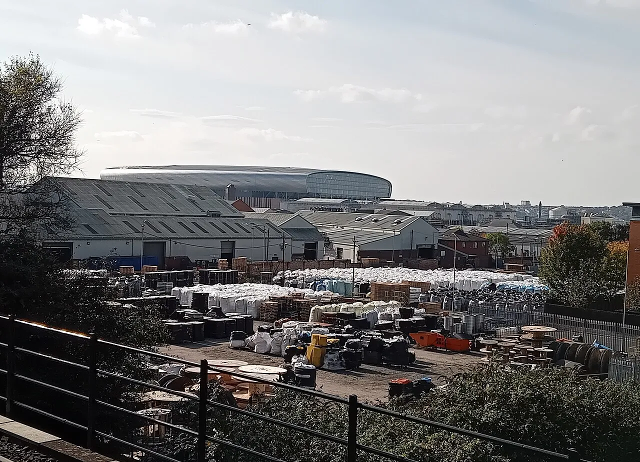 Hill Dickinson Stadium's curved roof rising above industrial yards and rooftops in the distance