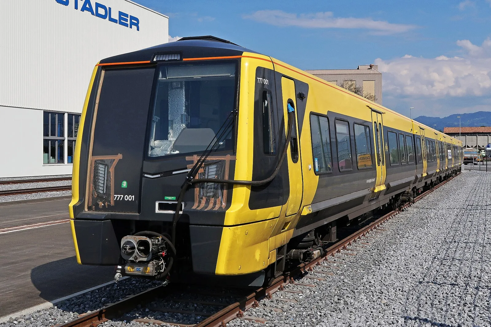 A Merseyrail Class 777 electric train in grey and yellow livery