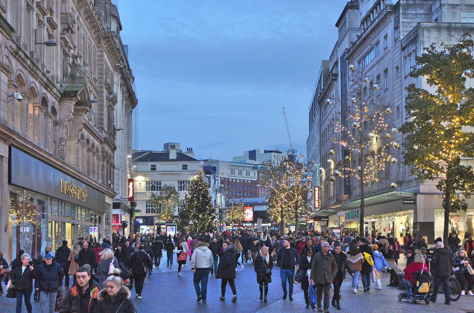 Shoppers walking along Church Street in Liverpool beneath strings of Christmas lights