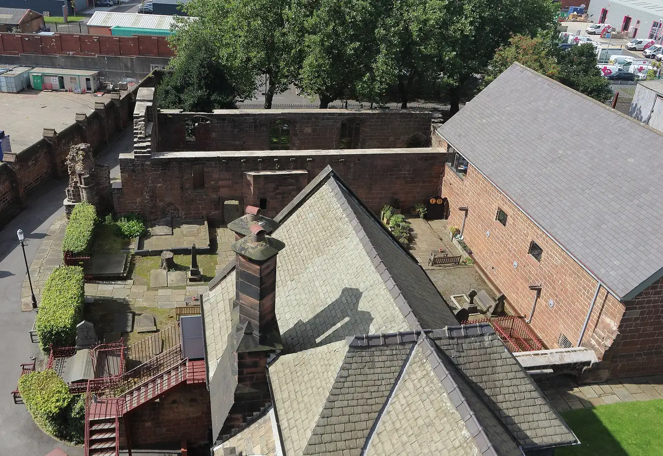 The stone ruins of Birkenhead Priory seen from above, with Birkenhead and the river beyond