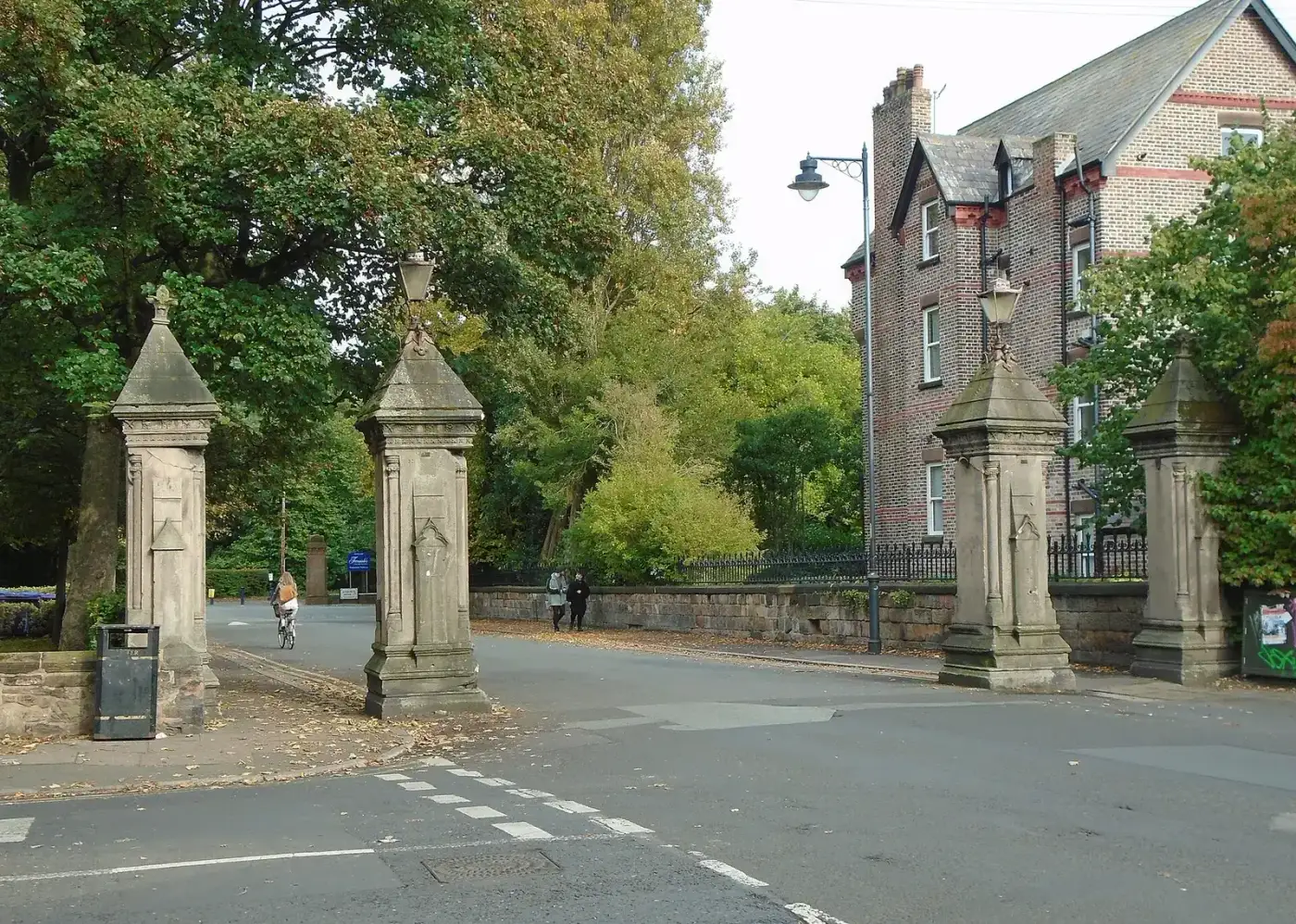 The stone gate piers at the Sefton Park end of Lark Lane with trees behind