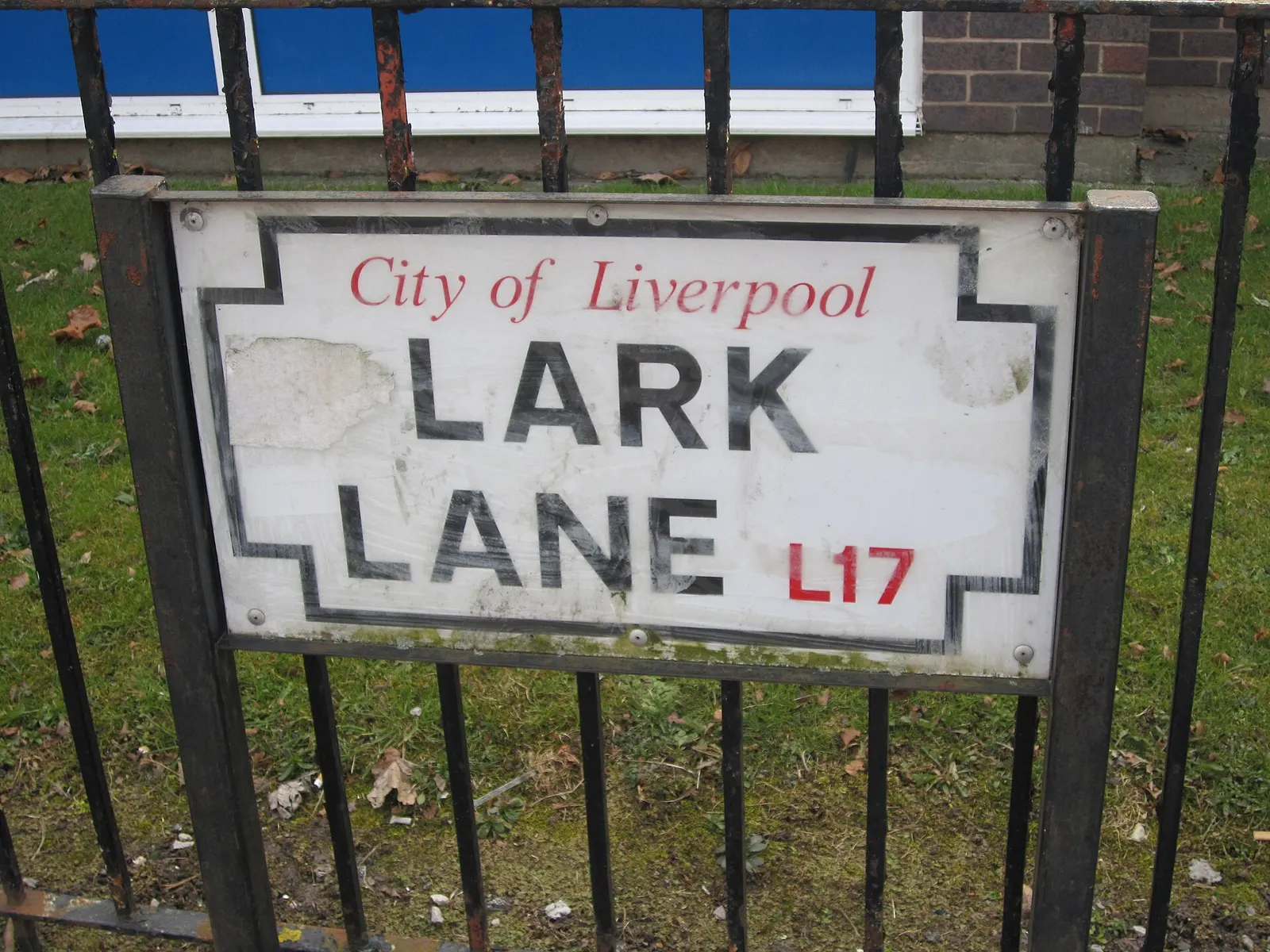 A City of Liverpool street sign reading Lark Lane L17 on black railings