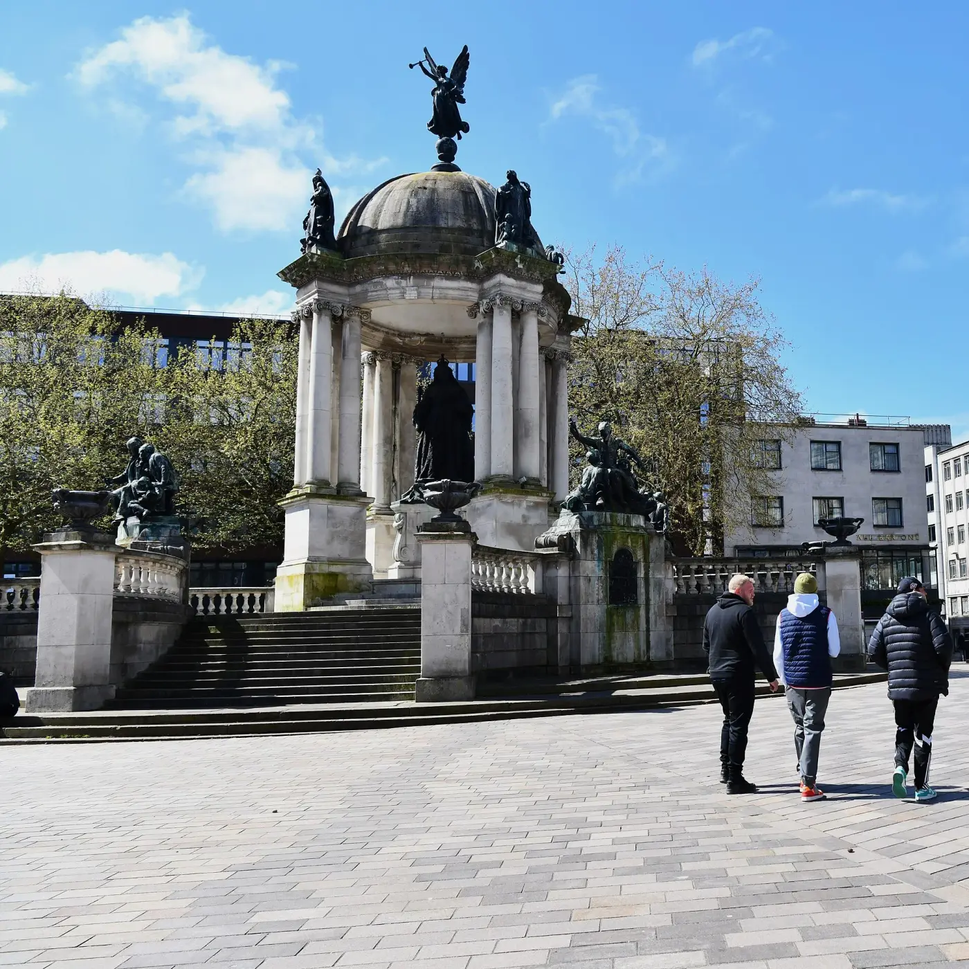 The Queen Victoria Monument in Derby Square, a domed stone canopy on coupled columns with sculpted figures and a bronze statue beneath