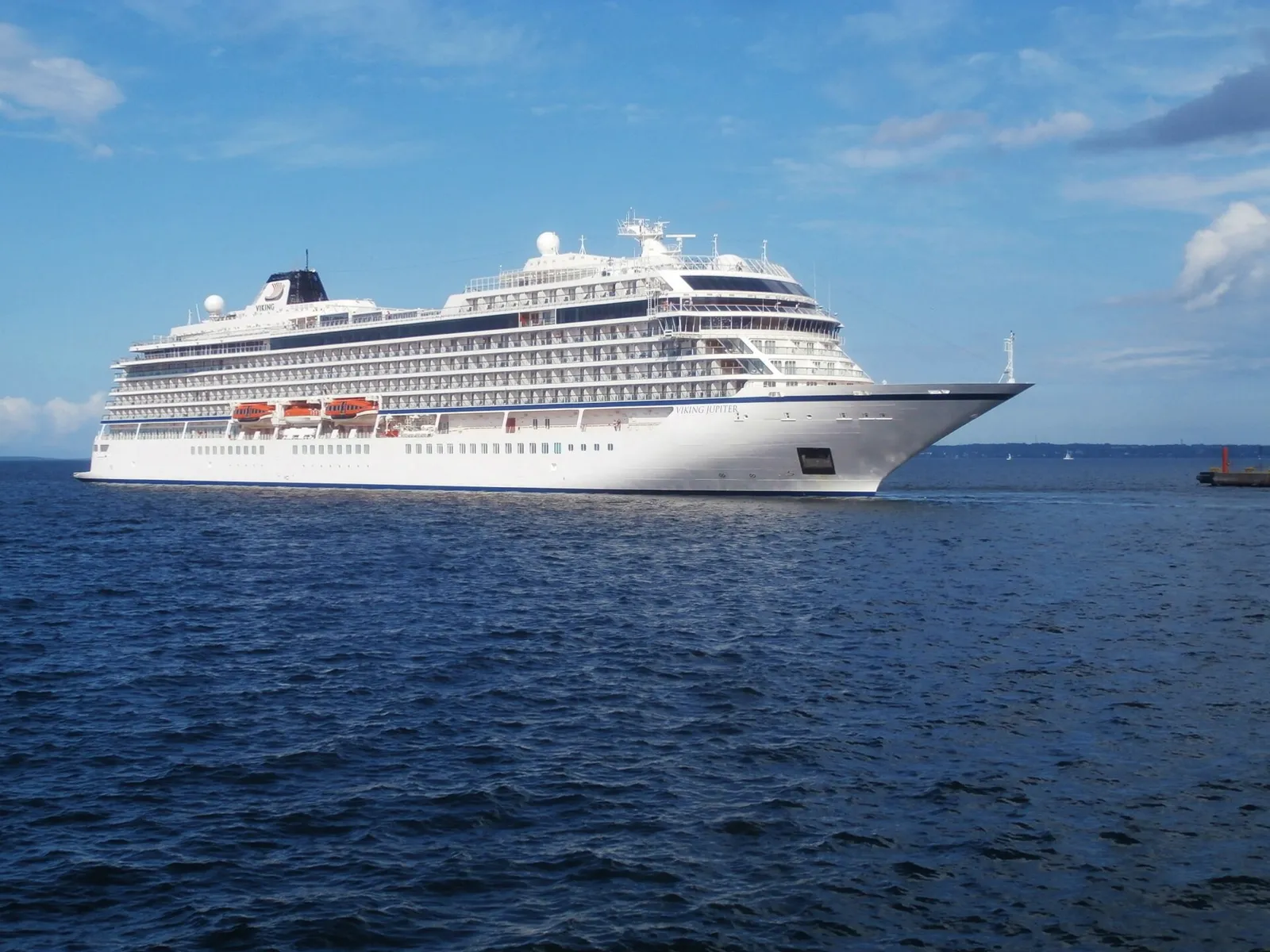 The cruise ship Viking Jupiter under way on open water with a clear blue sky