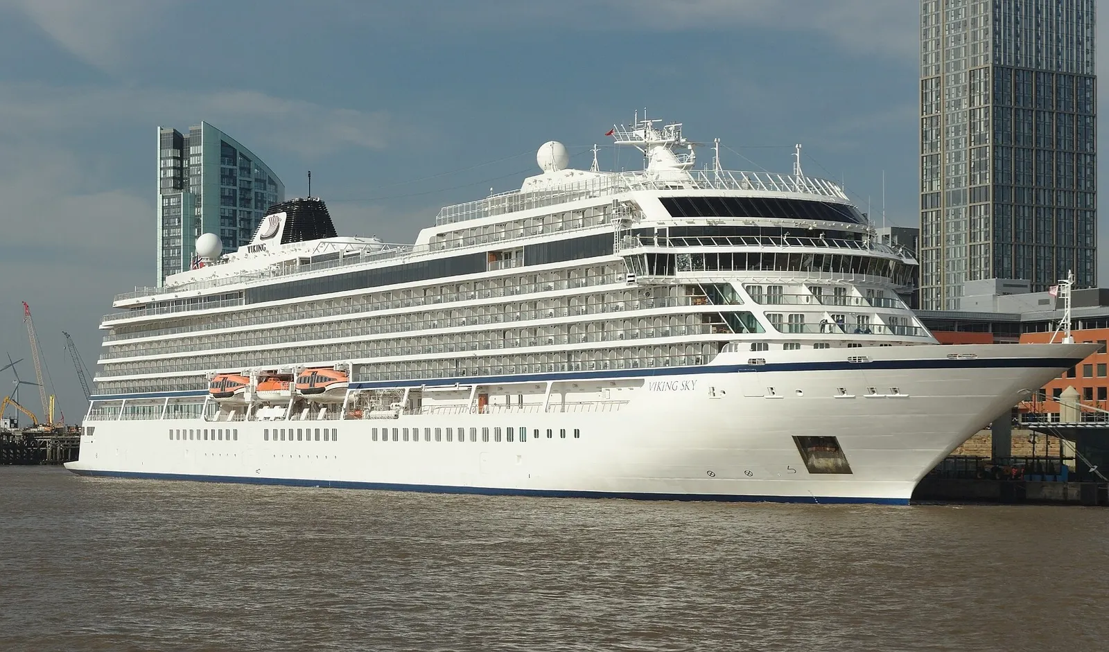 The bow of the cruise ship Viking Sky alongside at Liverpool with waterfront buildings behind
