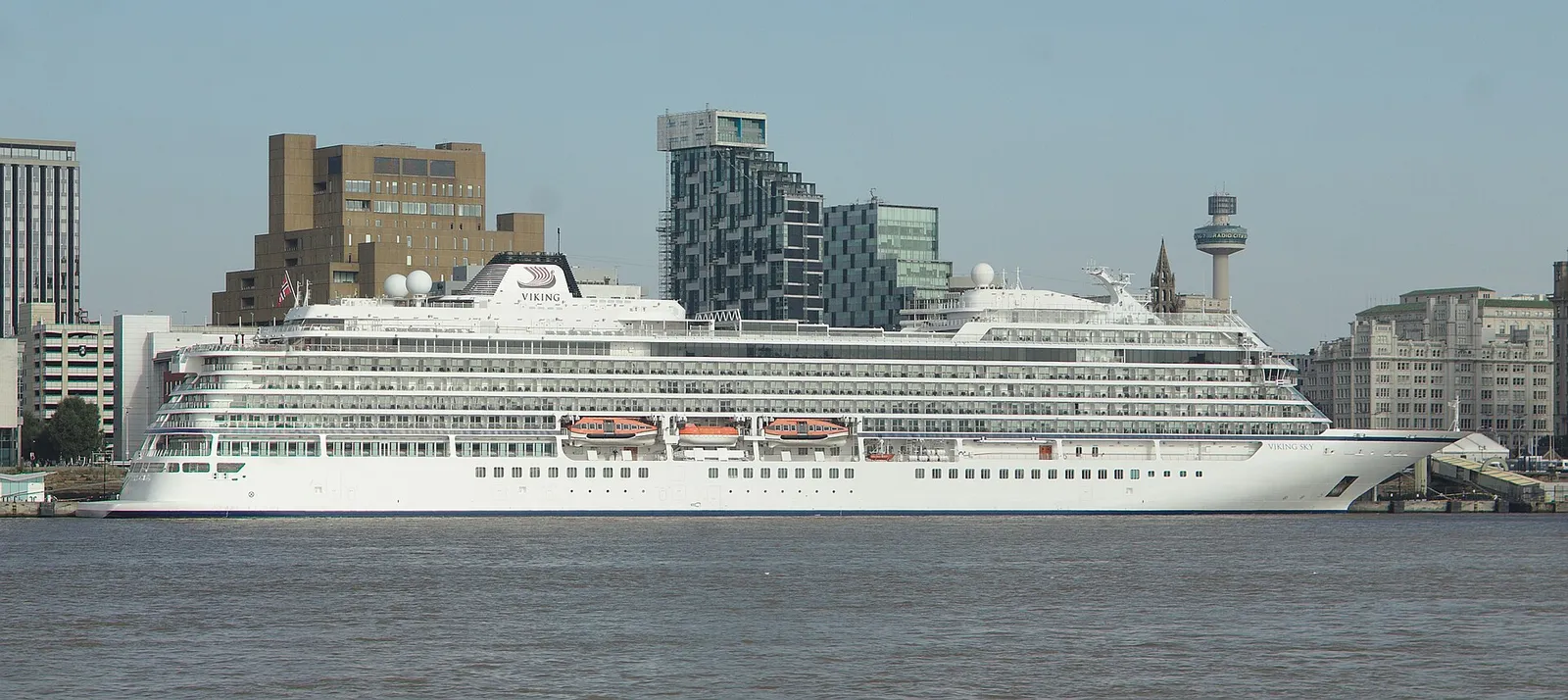 The cruise ship Viking Sky berthed on the Liverpool waterfront with city buildings and the Radio City tower behind it