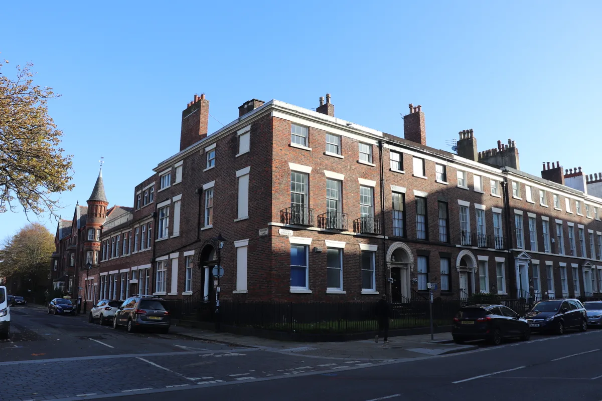 Brick Georgian terraces on the corner of Hope Street and Blackburne Place in Liverpool city centre, with parked cars along the kerb.