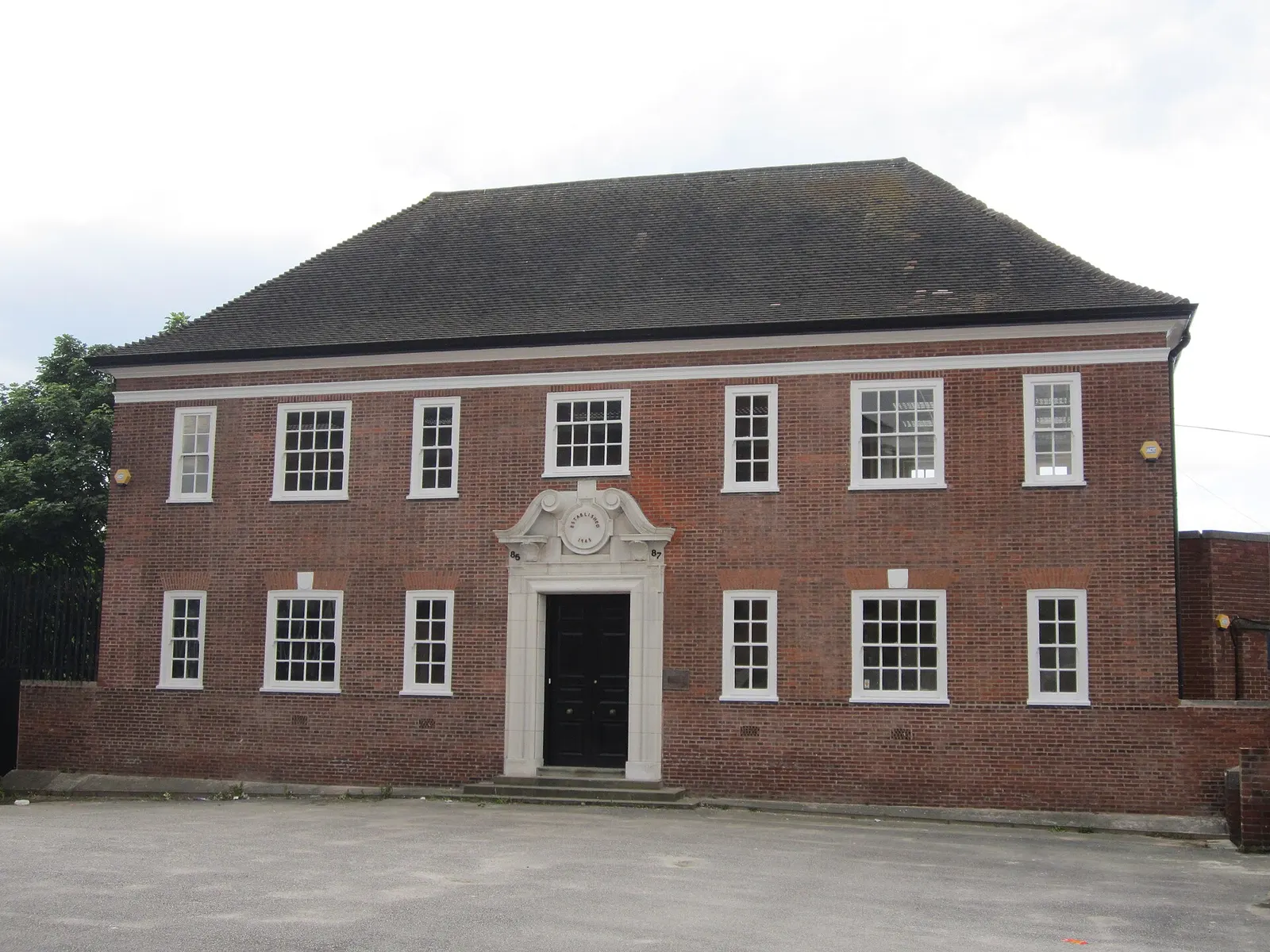 A two-storey red-brick building with white sash windows and a carved stone doorway, numbered 85 and 87, on Vauxhall Road