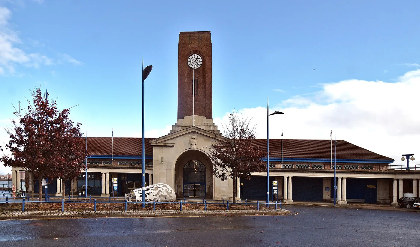 The Grade II listed Seacombe Ferry Terminal building with its tall clock tower, seen from the car park on a clear day