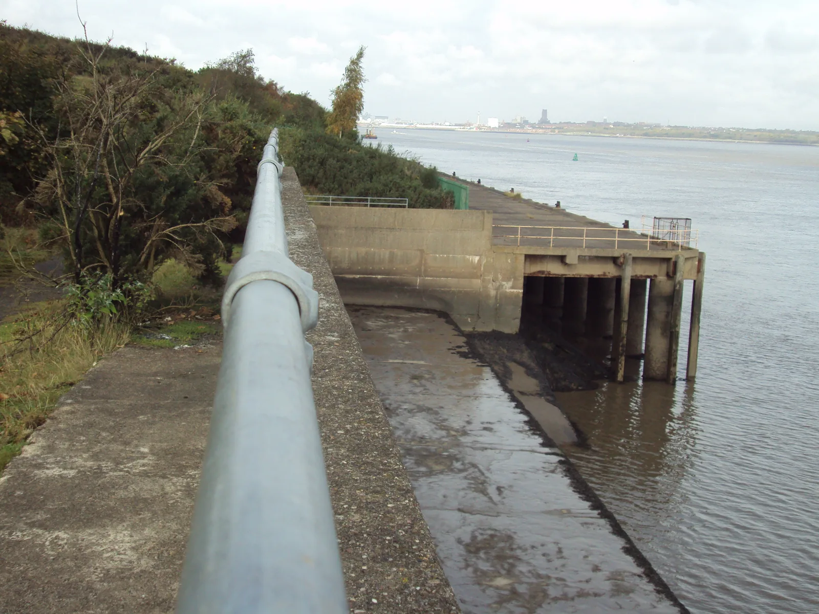 A concrete landing stage reaching out into the River Mersey at Bromborough on the Wirral bank, with low water and mud exposed around it