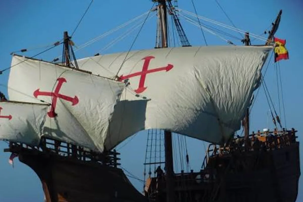 Close view of the Nao Santa María's sails, marked with red crosses, under a clear sky