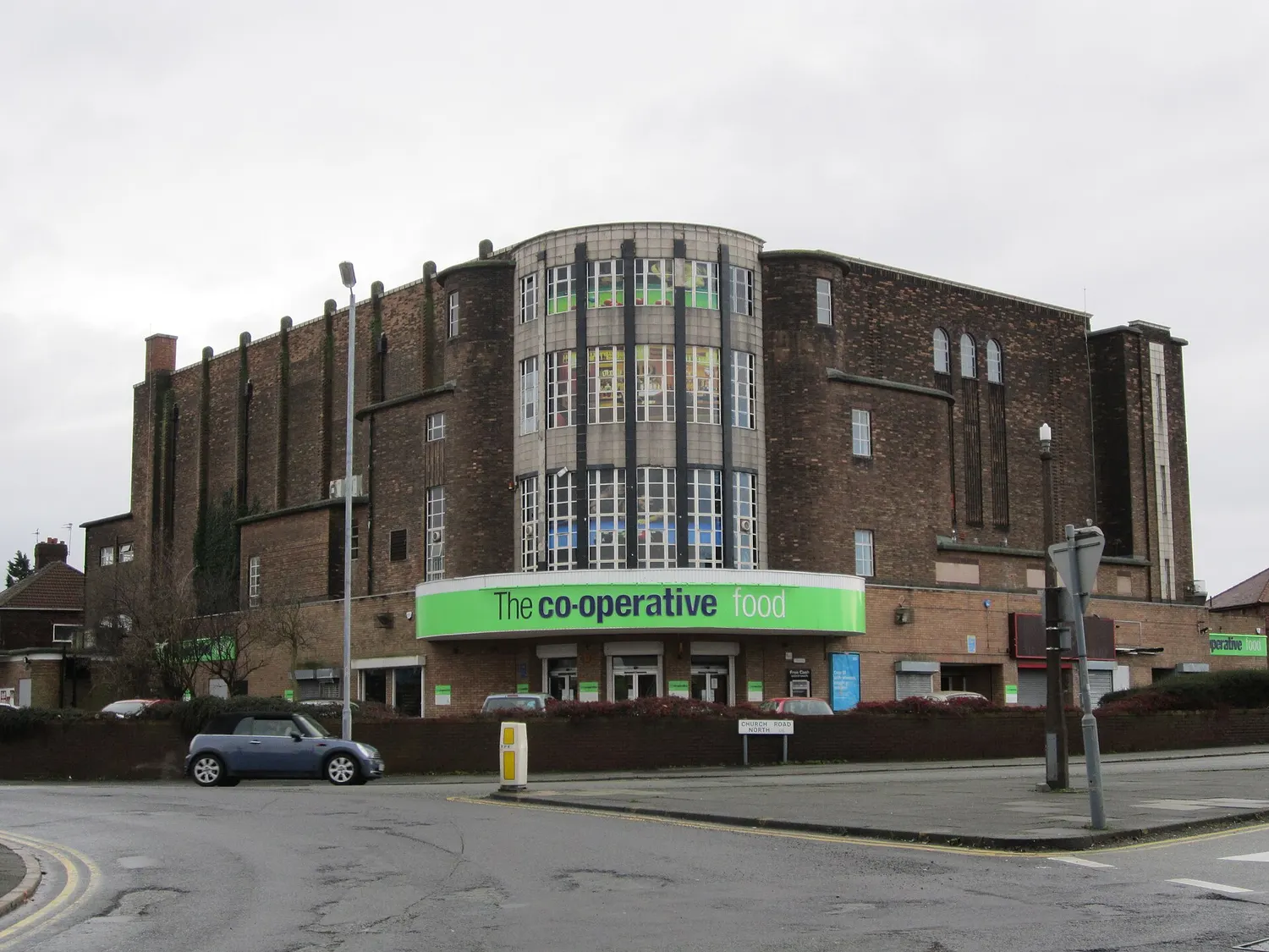 The curved corner entrance of the former Abbey Cinema in Wavertree seen from the pavement