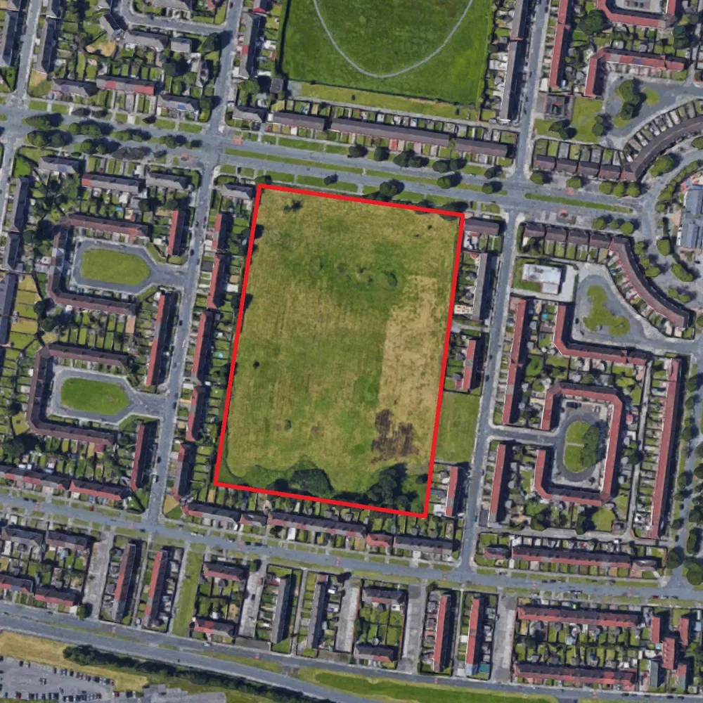Aerial view of a large rectangular grassed site outlined in red, surrounded by rows of terraced housing and streets in Speke
