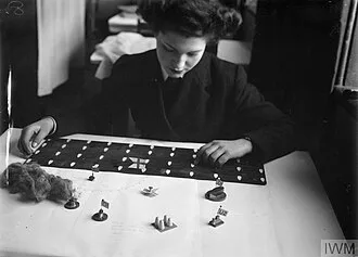 A Wren arranging model ships on a tactical game board