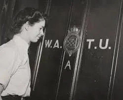 A Wren officer standing beside the W.A.T.U. door