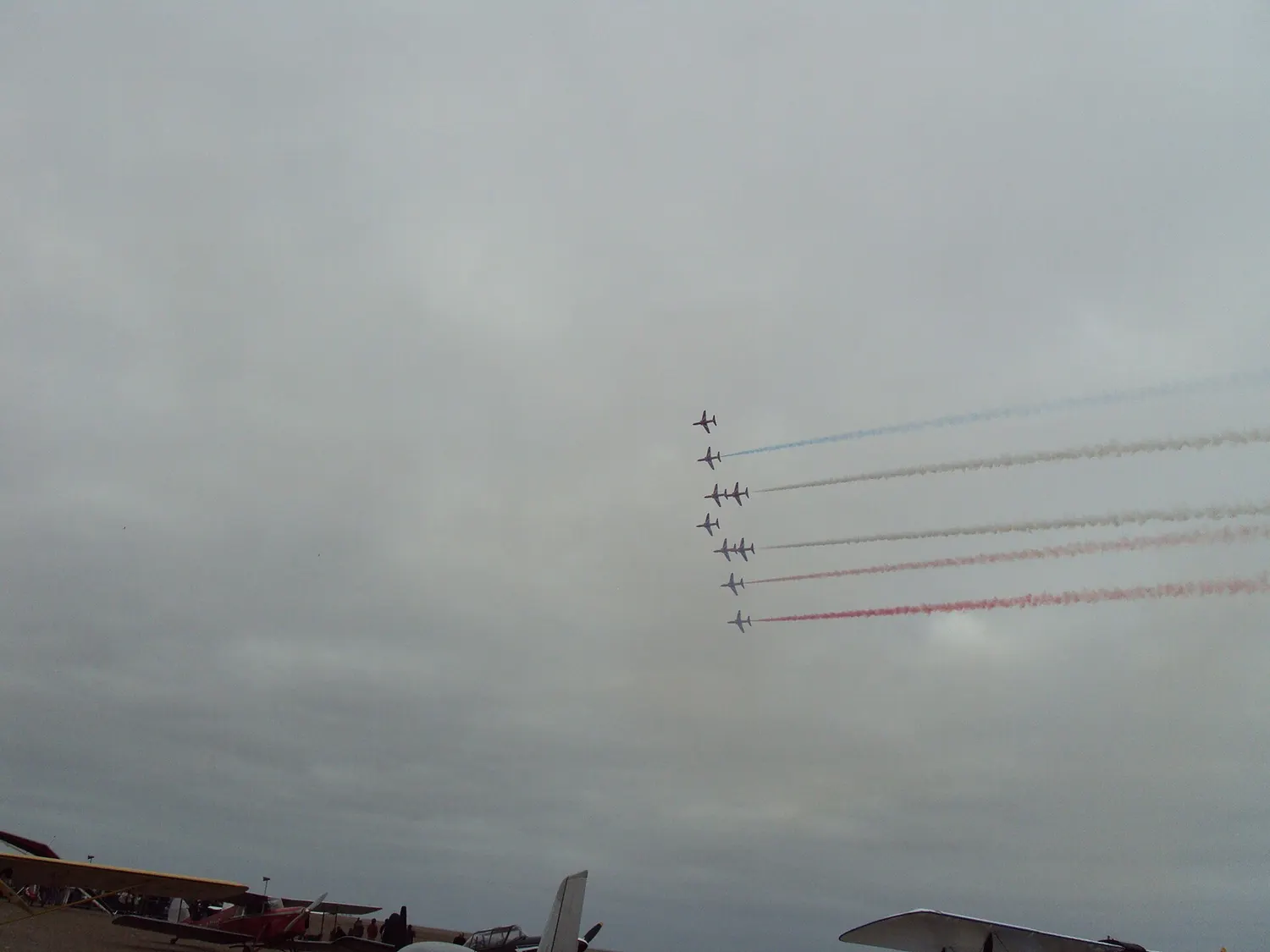 The Red Arrows flying in formation trailing red white and blue smoke over Southport