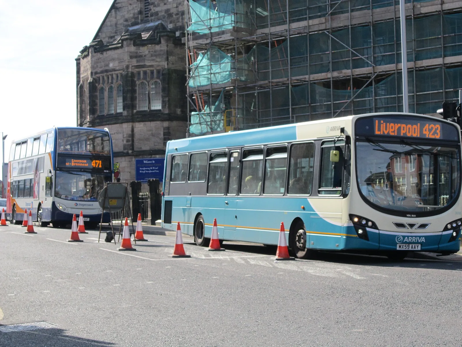 A Stagecoach 471 double-decker and an Arriva 423 single-decker bus parked by cones on Woodchurch Road, Birkenhead