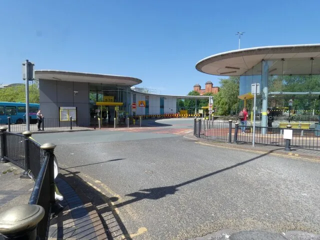 Birkenhead Bus Station with its curved canopy roofs and glass waiting area on a sunny day