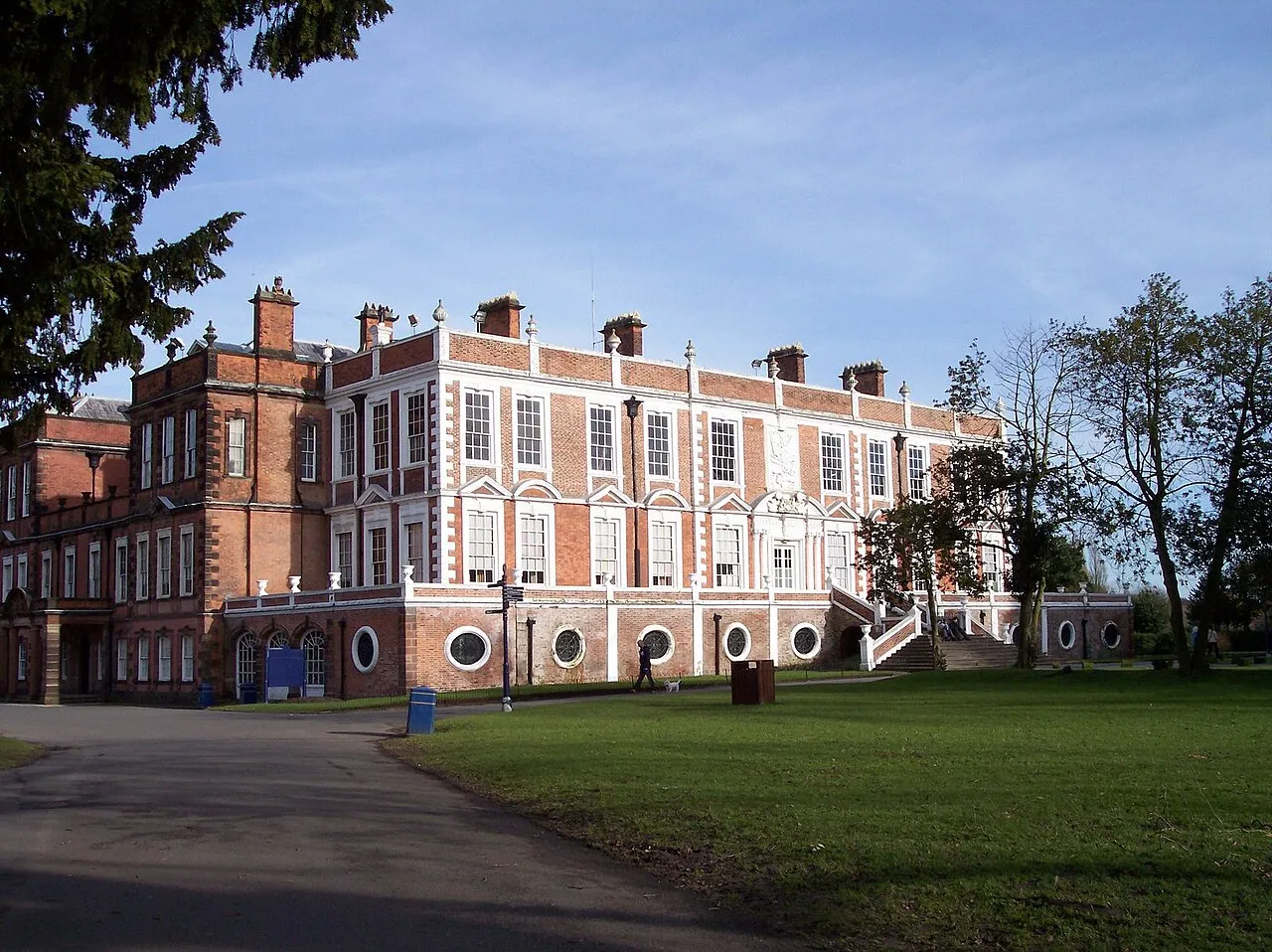 The brick and stone frontage of Croxteth Hall, seen across its lawn